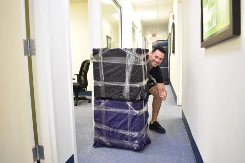 office moving services, owner posing with the desk packed